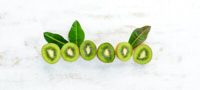 Sticker  Fresh kiwi on a white wooden table. Rustic style. Fruits. Top view. Free space for text.