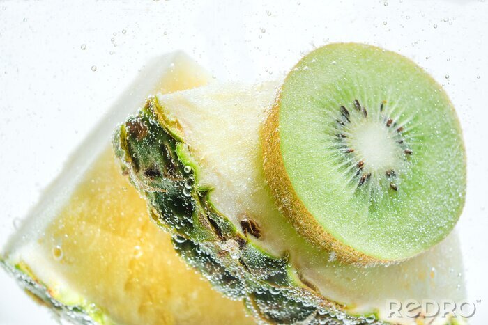 Sticker  Tranches d'ananas frais et de kiwi dans de l'eau claire et claire.