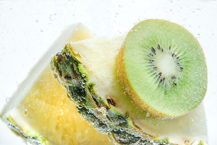 Sticker  Tranches d'ananas frais et de kiwi dans de l'eau claire et claire.