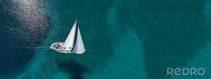 Tableau  Aerial drone ultra wide photo of beautiful sail boat sailing in tropical exotic bay with emerald clear sea
