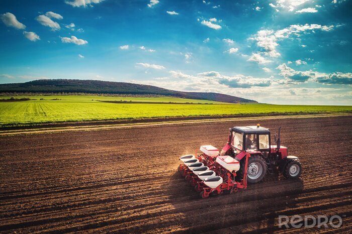 Tableau  Agriculteur avec tracteur ensemencement des cultures au champ, vue aérienne de drone
