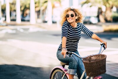 Tableau  Beautiful and cheerful adult young woman enjoy bike ride in sunny urban outdoor leisure activity in the city - happy people portrait - trendy female outside having fun