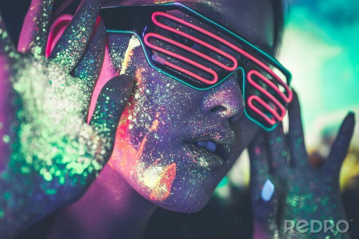Tableau  Beautiful young woman dancing and making party with fluorescent painting on her face. Neon facial portraits