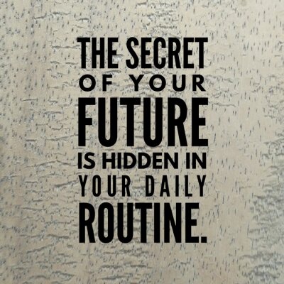 Tableau  Citation de motivation "Le secret de votre avenir est caché dans votre routine quotidienne." sur un fond en bois.
