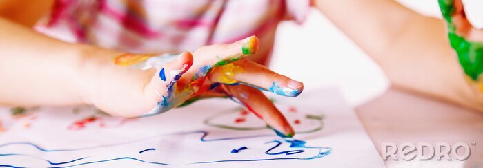 Tableau  Close up young girl painting with colorful hands. Art,  creativity and painting concept. Horizontal image.