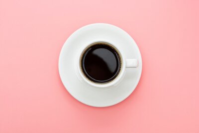 Coffee cup isolated on pink table. Top view, flat lay abstract black coffee drink with copy space.