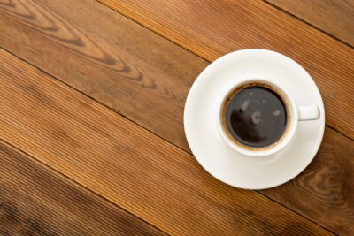 Tableau  Coffee cup isolated on wooden table. Top view, flat lay coffee drink with copy space.