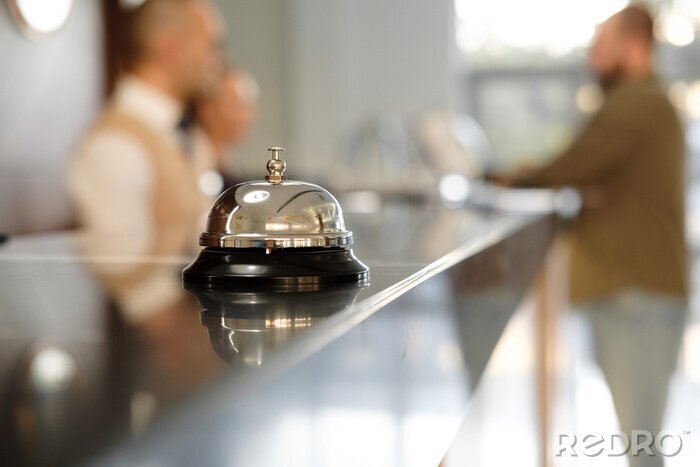 Tableau  Comptoir de réception de luxe moderne avec cloche. Service Bell localiser à la réception. Silver Call Bell sur la table, réceptionnistes et client sur le fond. Vérifiez à l'hôtel. Concept.