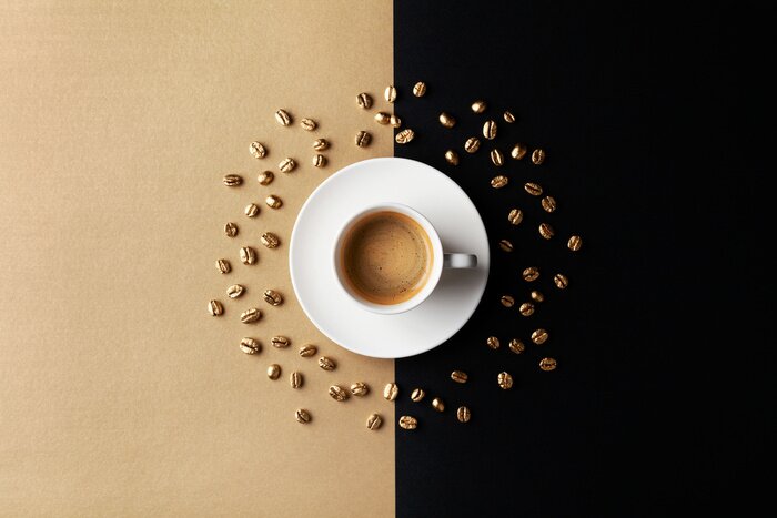 Tableau  Cup of coffee and coffee beans on gold black background. Creative flat lay. Top view.