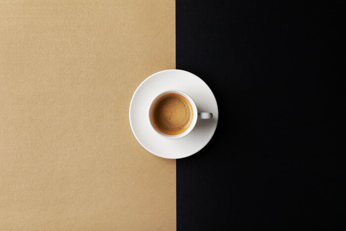 Tableau  Cup of coffee on gold black background. Minimalistic flat lay. Top view.