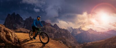 Tableau  Cycling outdoor adventure. Man cycling on electric bike, rides mountain trail. Man riding on bike in Dolomites mountains landscape. Cycling e-mtb enduro trail track. Outdoor sport activity.