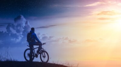 Tableau  Cyclist on a mountain top between day and night