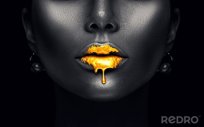 Tableau  Des gouttes de peinture dorée s'écoulent des lèvres sexy, des gouttes de liquide dorées sur la bouche de la belle modèle, maquillage de peau noire abstraite et créative. Visage de femme de beauté isol