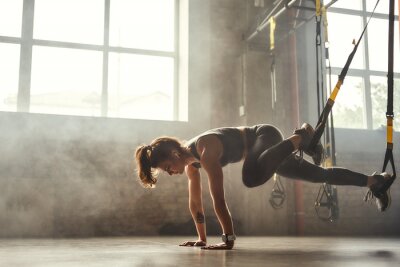 Femme s'entraînant avec des sangles TRX