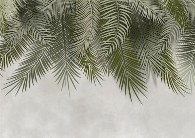 Feuilles de palmier vertes suspendues à un mur de béton