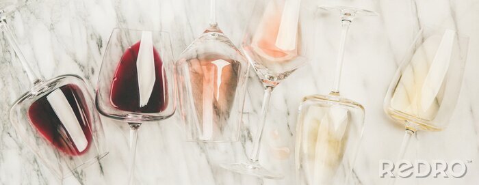 Tableau  Flat-lay de vin rouge, rose et blanc dans des verres et des tire-bouchons sur fond de marbre gris, vue de dessus, composition large. Bar à vin, établissement vinicole, concept de dégustation de vin