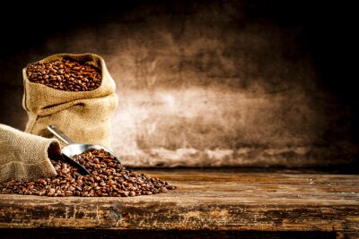 Tableau  Fresh old sack of coffee grains and brown old wall background 