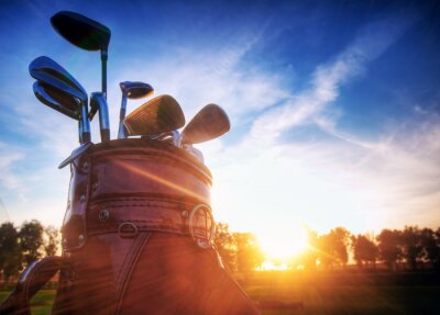 Golf engins, clubs au coucher du soleil sur le parcours de golf