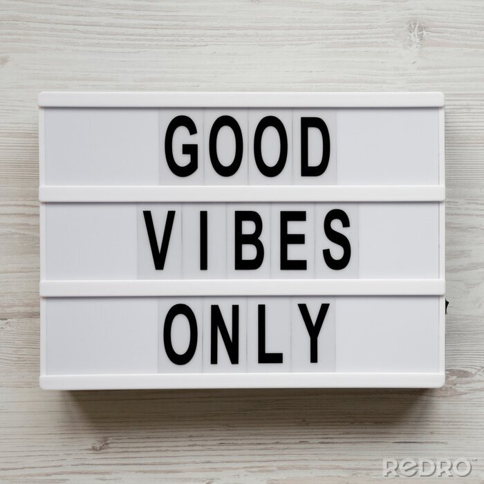 Tableau  'Good vibes only' words on lightbox over white wooden surface, top view. From above, overhead, flat lay. Copy space.