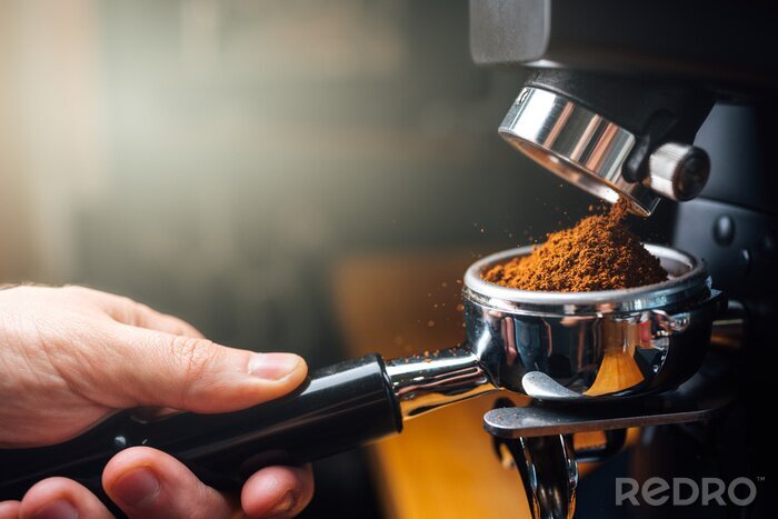 Tableau  ground coffee pouring into a portafilter with a grinder