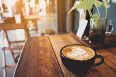 Tableau  Latte cup on wooden table blur coffee shop background