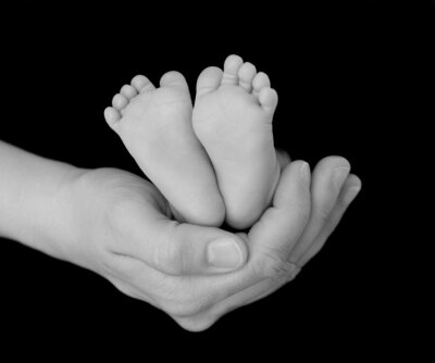 Les pieds des nouveau-nés Bercée dans la main de Parent
