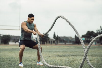 Tableau  Man doing workout using battle ropes on the ground