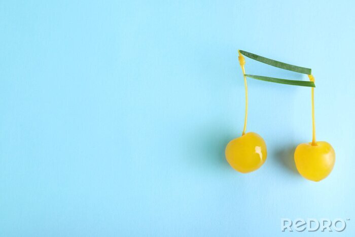 Tableau  Musical note made of onion and cocktail cherries on color background, top view. Space for text