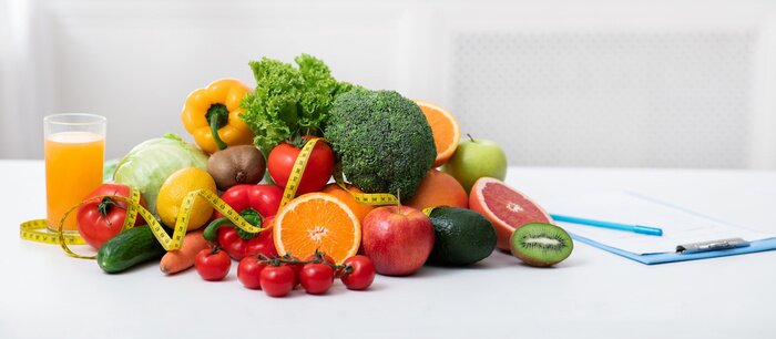 Tableau  Nutritionist's workplace with fruits, vegetables, measuring tape on table