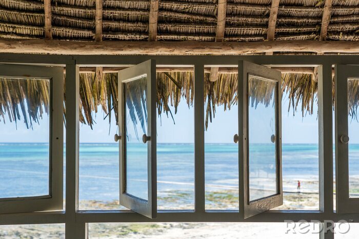 Tableau  Open windows of thatched roof veranda overlooking the turquoise ocean on the island of Zanzibar, Tanzania, Africa