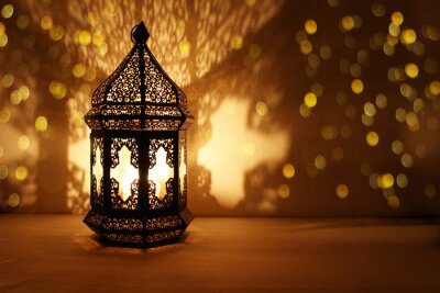 Tableau  Ornamental Arabic lantern with burning candle glowing at night and glittering golden bokeh lights. Festive greeting card, invitation for Muslim holy month Ramadan Kareem. Dark background.