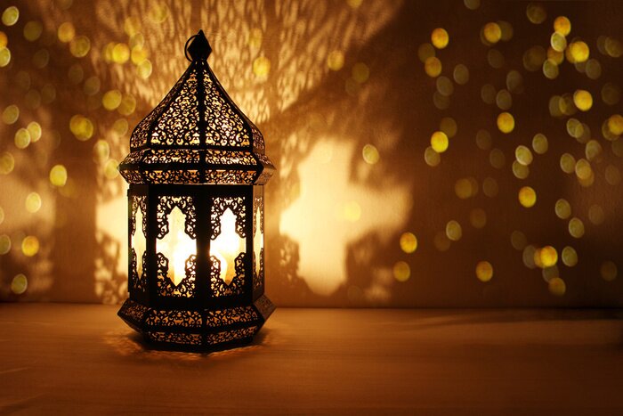 Tableau  Ornamental Arabic lantern with burning candle glowing at night and glittering golden bokeh lights. Festive greeting card, invitation for Muslim holy month Ramadan Kareem. Dark background.