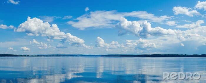Tableau  Panorama of calm lake, Kama river blue sky with clouds reflected in the water.