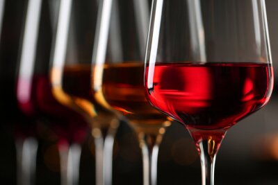 Tableau  Row of glasses with different wines on blurred background, closeup