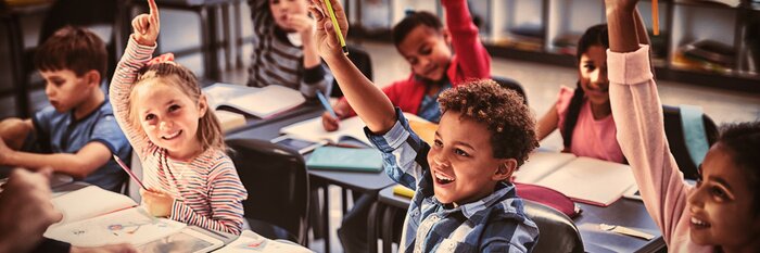 Tableau  Schoolkids raising their hands in classroom