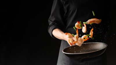 Tableau  Seafood, Professional cook prepares shrimps with sprigg beans. Cooking seafood, healthy vegetarian food and food on a dark background. Horizontal view. Eastern kitchen