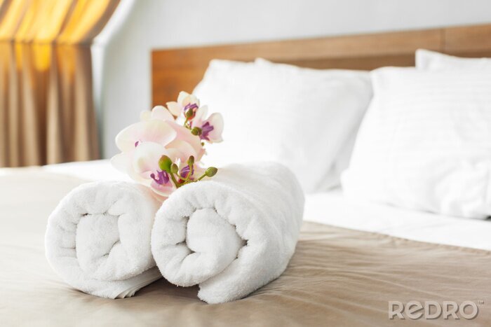 Tableau  serviettes et fleurs sur le lit dans la chambre d'hôtel
