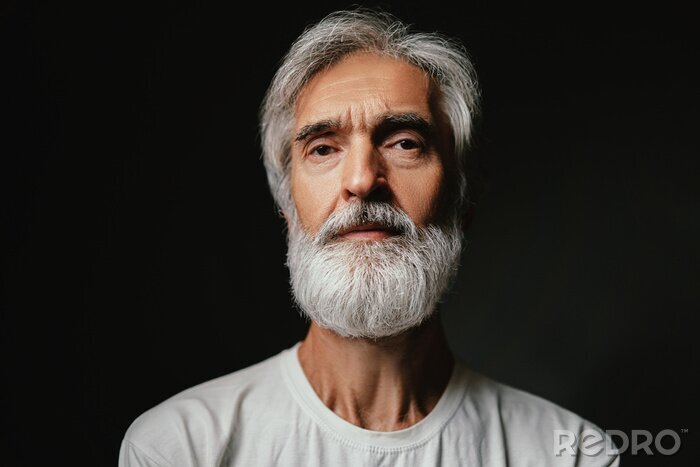 Tableau  Studio portrait of frowning senior man with gray beard.