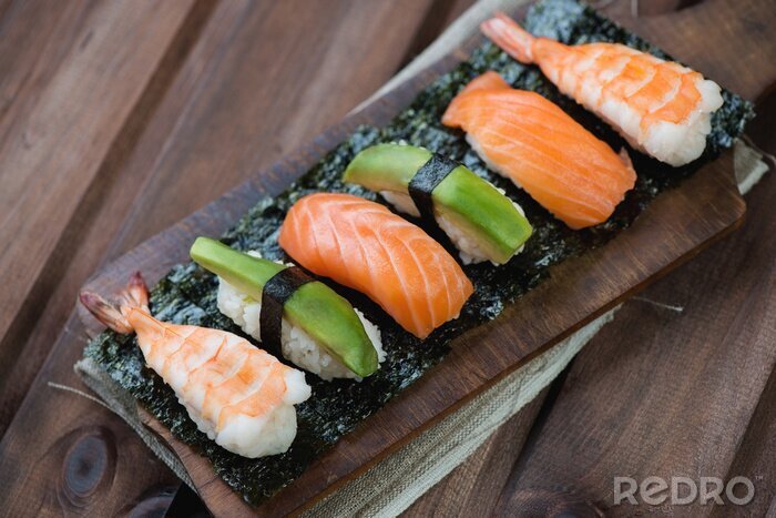 Tableau  Sushi avec saumon, crevettes et avocat, fond en bois rustique
