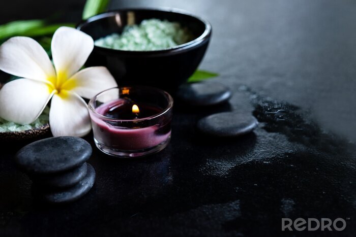 Tableau  Thai Spa.  Top view of white Plumeria flower setting for massage treatment and relax on concrete blackboard with copy space.  Green leaf with black stones pile for spa therapy. Healthy Concept.