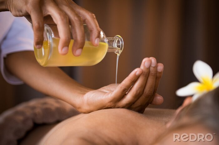 Tableau  Thérapeute versant de l'huile de massage au spa
