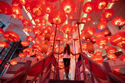 Tableau  Woman walking and enjoying traditional red lanterns decorated for Chinese new year Chunjie. Asian culture inspiration. Trend lava color.