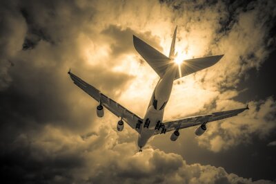 Tableau  avion de passagers d'atterrissage à travers les nuages ​​d'or