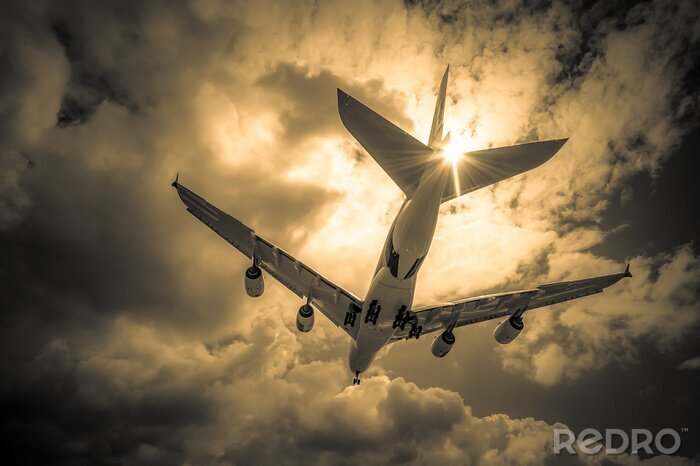 Tableau  avion de passagers d'atterrissage à travers les nuages ​​d'or