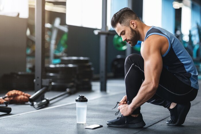 Tableau  Young athlete tying sneakers laces at gym