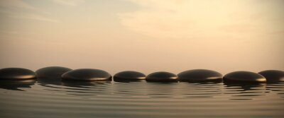 Zen pierres dans l'eau sur le lever du soleil